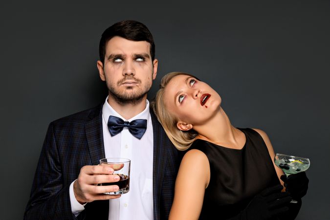 A woman and a man in Halloween costumes on a dark background