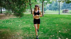 Female athlete running through a park
