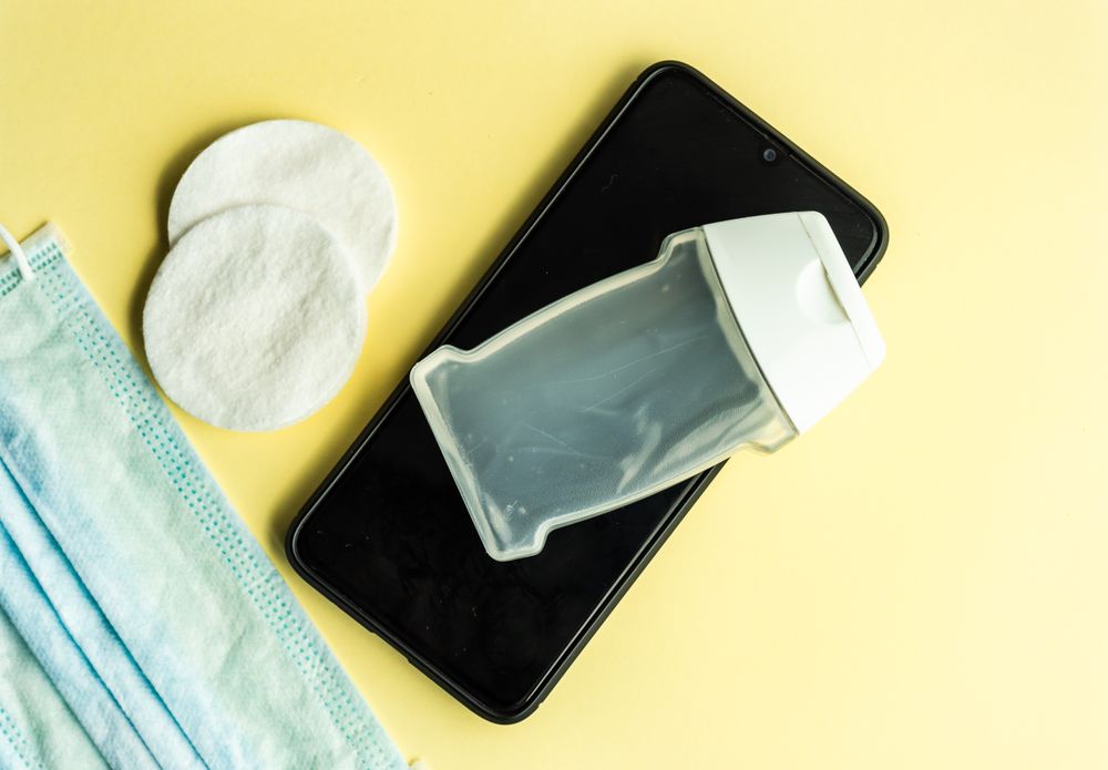 Top view of yellow table with soap, phone and cotton