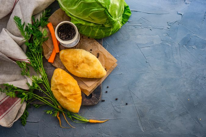 Traditional pies with cabbage and carrot on kitchen counter