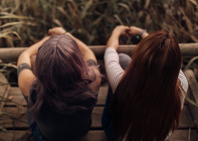 Women sitting on wooden pier in nature