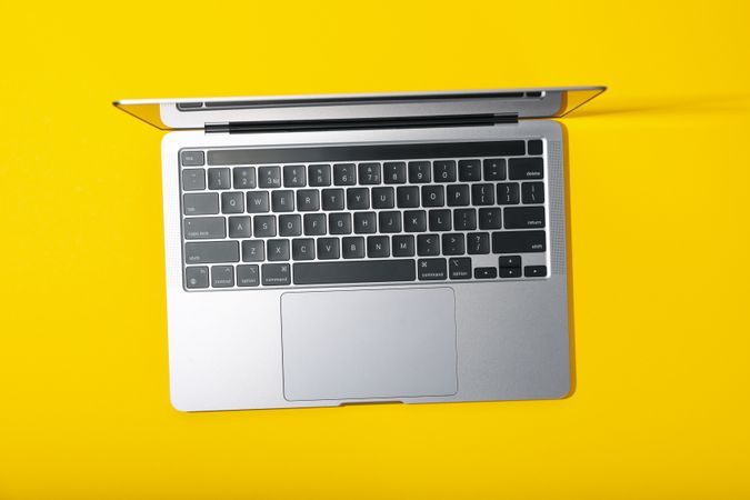 Top view of open laptop on yellow desk