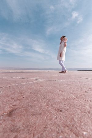 Thoughtful relaxed tourist enjoying unusual scenery of pink salt lake