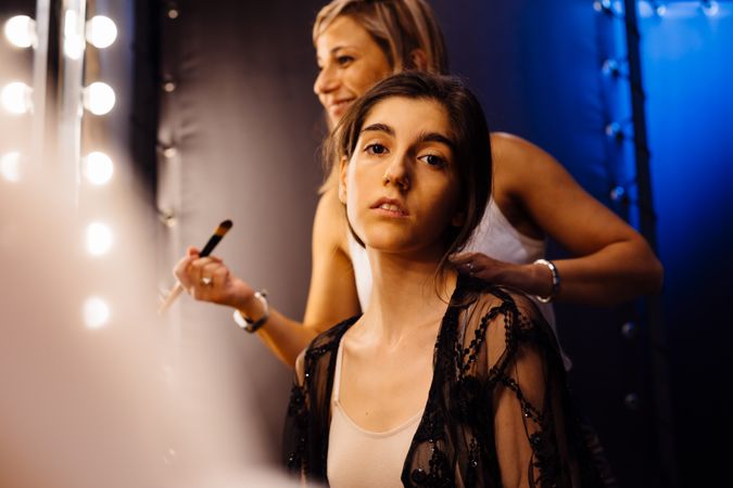 Makeup artist doing makeup for young female artist