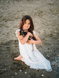 Girl with little dog on sandy beach