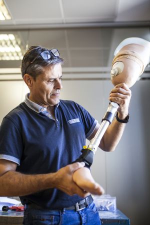 man fixing a prosthesis in a workshop