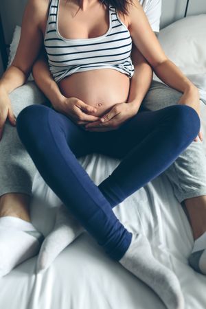 Pregnant woman embraced by her husband
