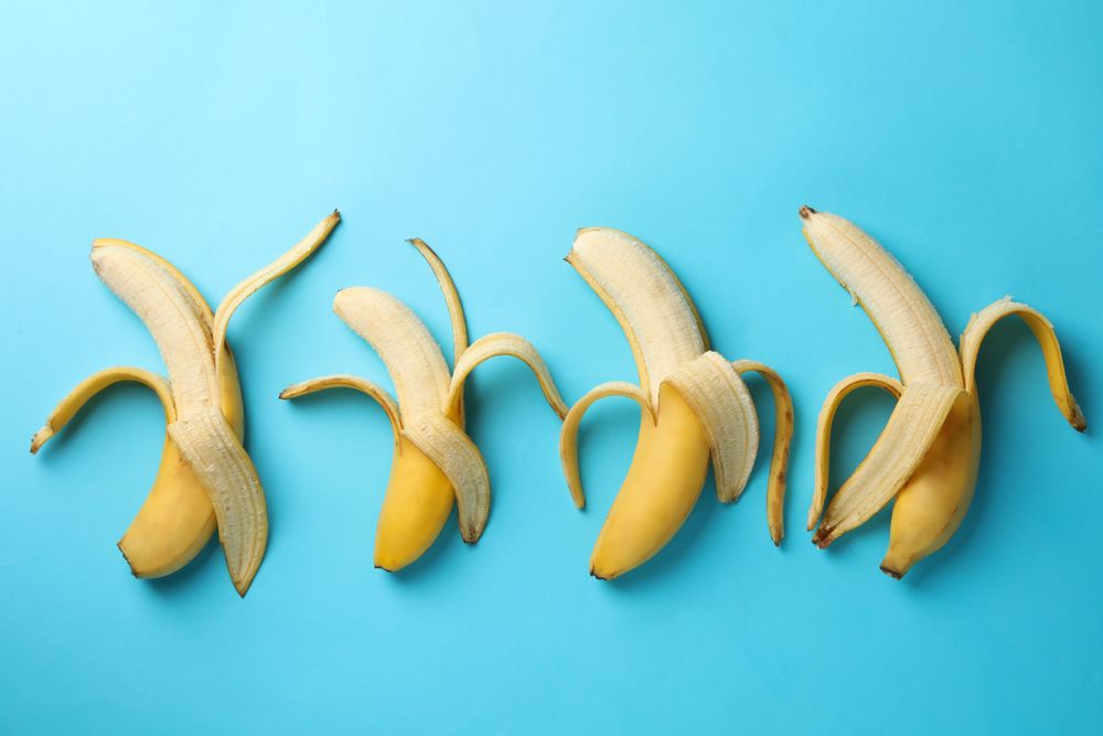Opened bananas on blue background. Fresh fruit