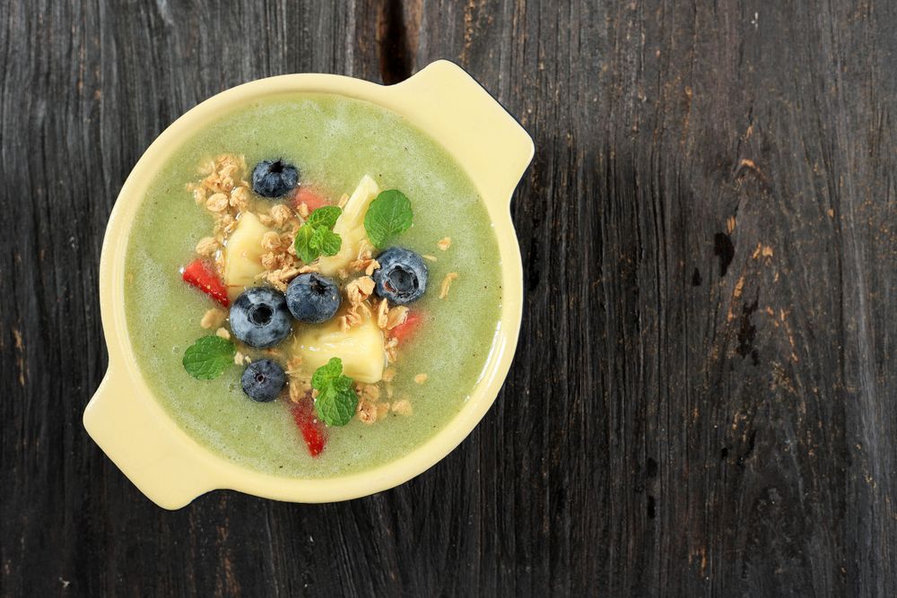 Top View Fresh Kiwi Smoothie Bowl on Wooden Table