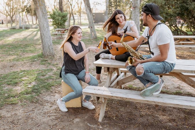 Young musicians drinking beer in park