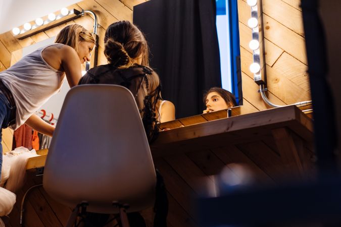Makeup artist doing makeup for young female artist
