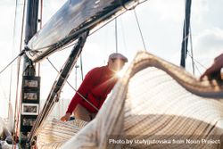 Sailor on yacht arranging the covering beOep5