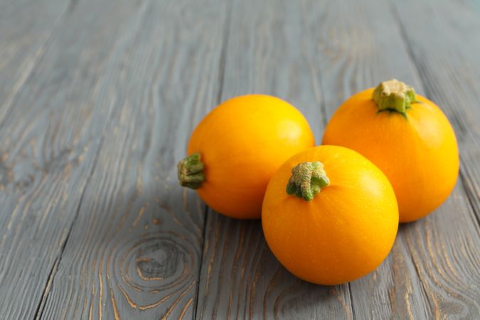 Round zucchini on wooden background, space for text