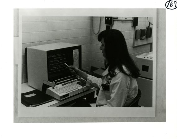 Pharmacist seated at a computer terminal