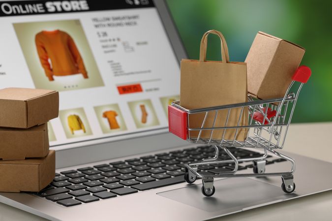 Online Shopping Concept with Cart and Boxes on Laptop Keyboard