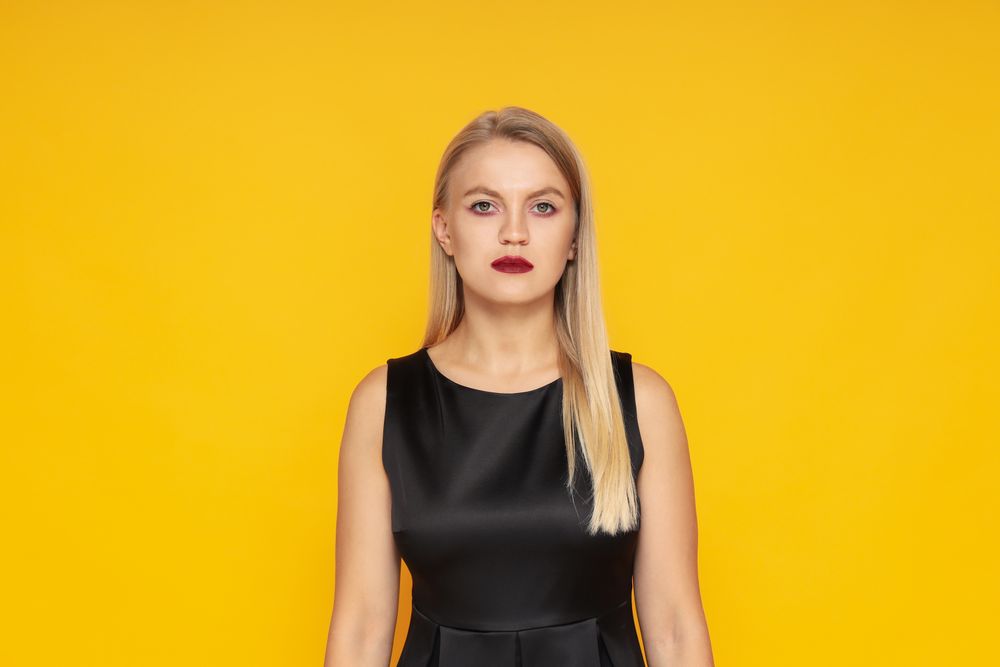 Concept of Halloween, young woman on yellow background