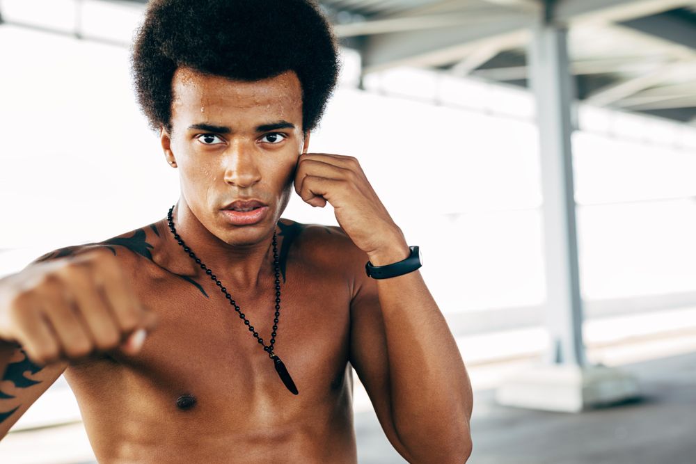 Man with shirt off in boxing practice