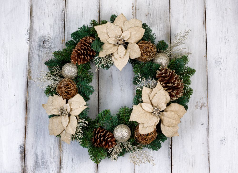 Holiday Poinsettia Christmas wreath on rustic wooden boards