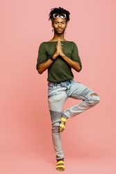 Portrait of a man in green shirt, jeans and hands together in prayer, yoga pose