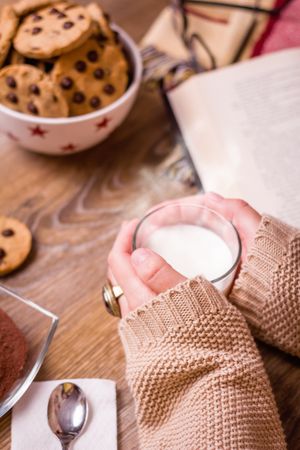 Female hands with hot drink and chocolate cookies