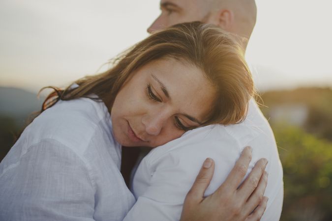 Tender couple embracing while standing at rural field