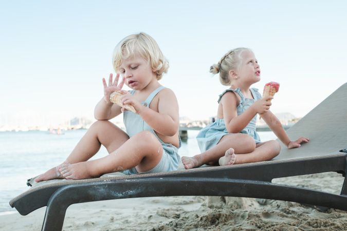 Children enjoying ice cream on sandy beach