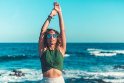 Stylish woman standing near sea