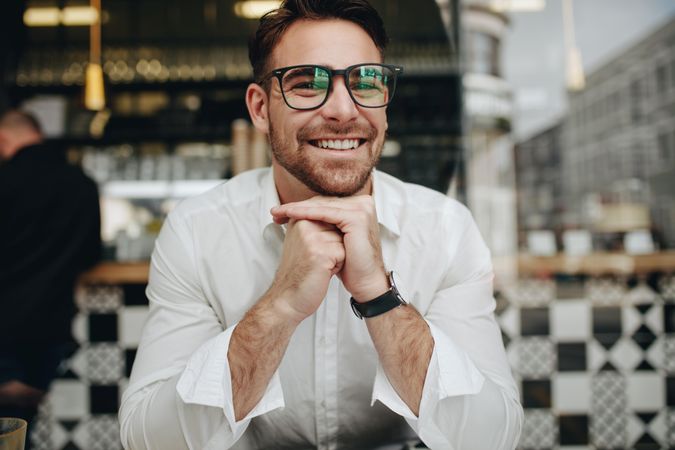 Man sitting in a cafe in relaxed mood and smiling