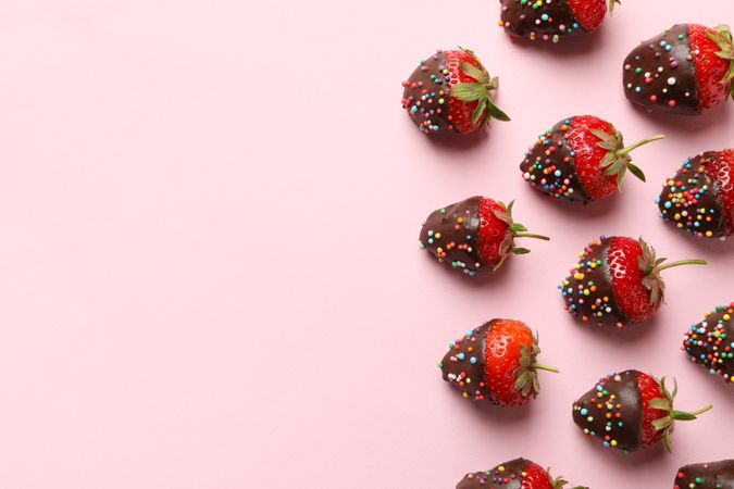 Chocolate fondue. Flat lay with strawberry in chocolate on pink background