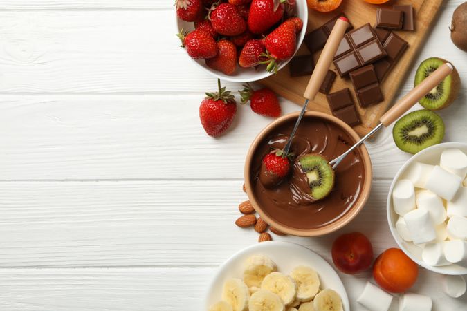 Composition with ingredients for chocolate fondue on wooden background. Cooking fondue