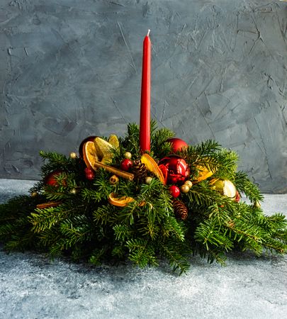 Center piece on wintry table with fir, baubles and candle