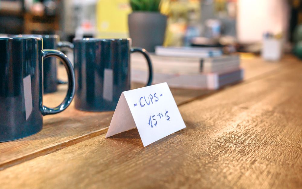 Close up of articles price label over wooden counter in local store with industrial style decoration