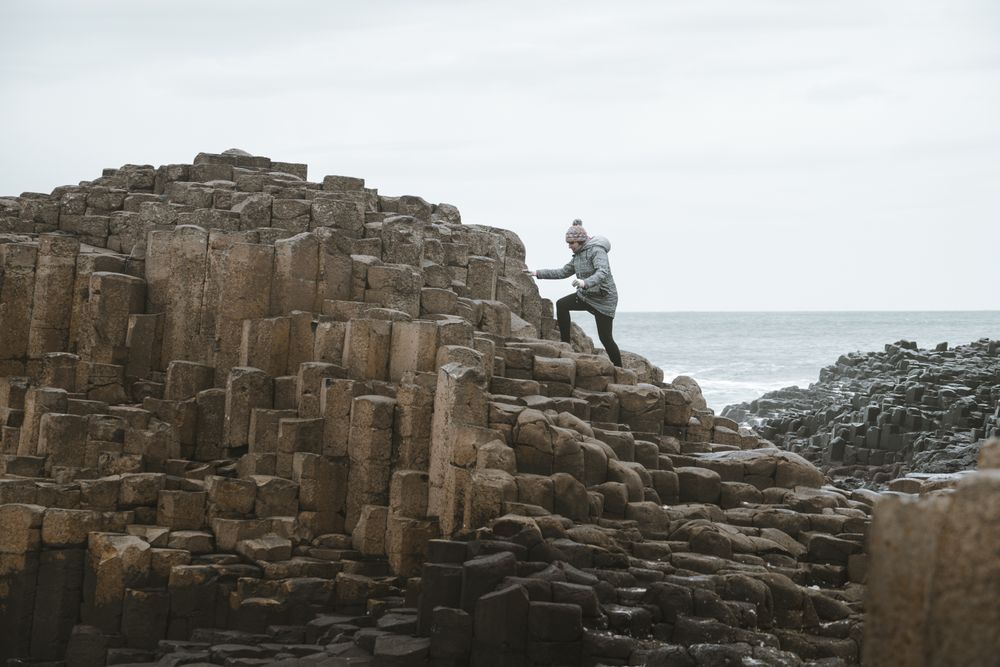 Female standing on cliff and contemplating