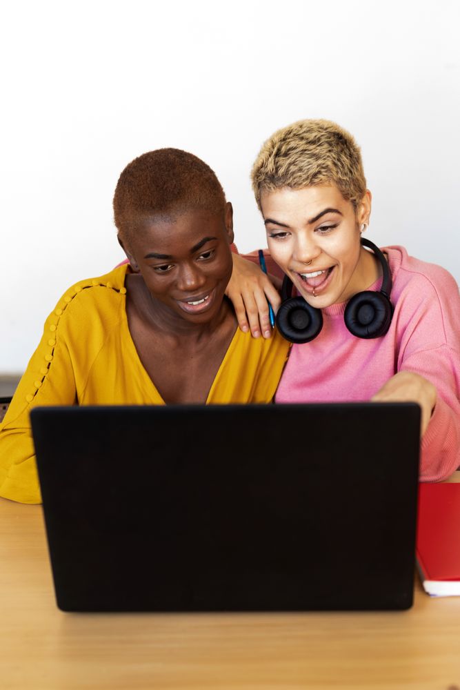 Female friends smiling at laptop