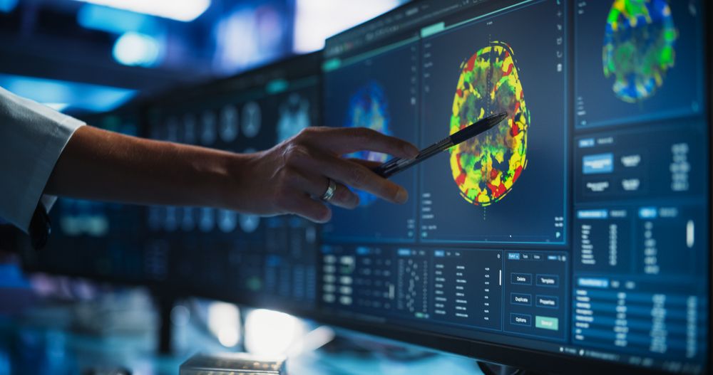 Modern Medical Research Center: Anonymous Doctor Pointing At Desktop Computer Monitor With CT Scan Of Human Spinal Cord.