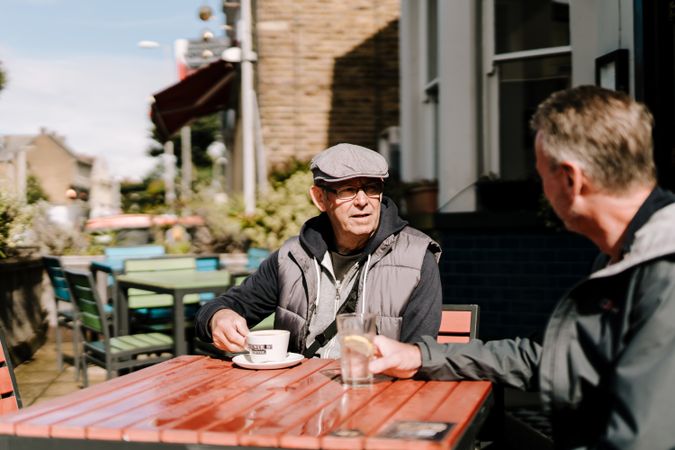 Two older men at an outdoor cafe