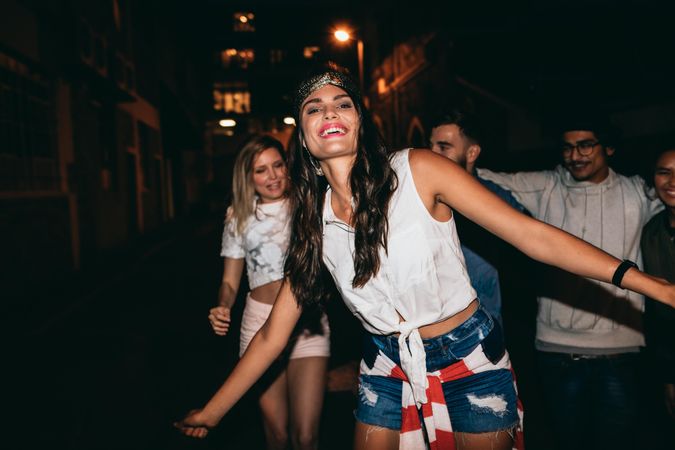 Happy young female in party with friends at night