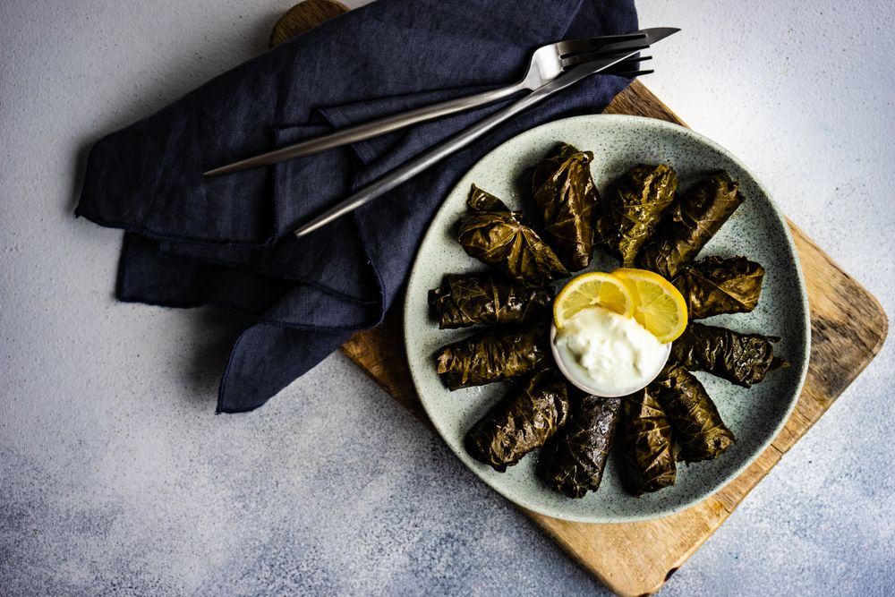 Top view of grey plate with traditional Georgian dolma dish with dip
