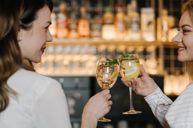 Cheerful women drinking cocktails in bar