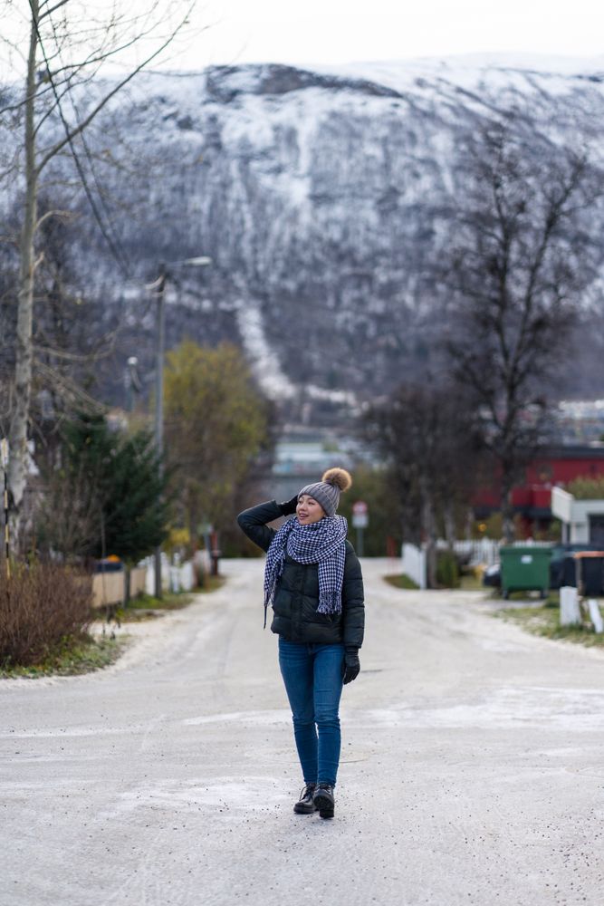 Female tourist in warm wear exploring suburbs of city