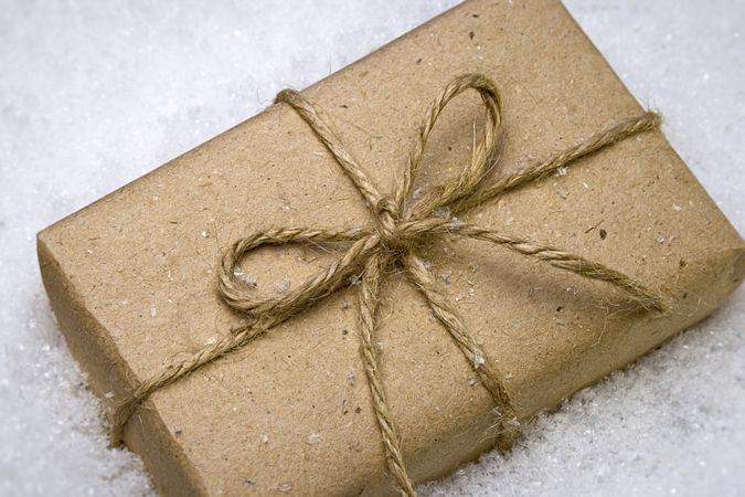 Wrapped brown paper present laying in the snow