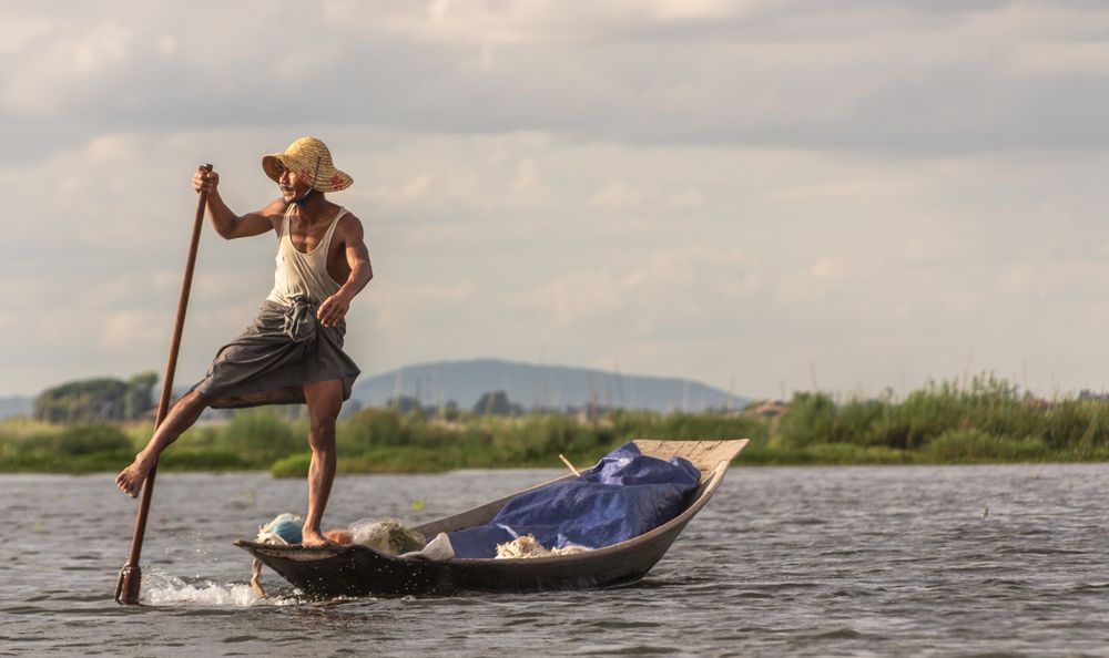 Shan, Myanmar - June, 25 2012: Anonymous fisherman standing on boat