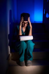 Concentrated female medic reading documents on stairs