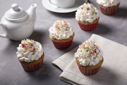 Tasty party cupcakes on the table. Cupcakes with whipped cream.