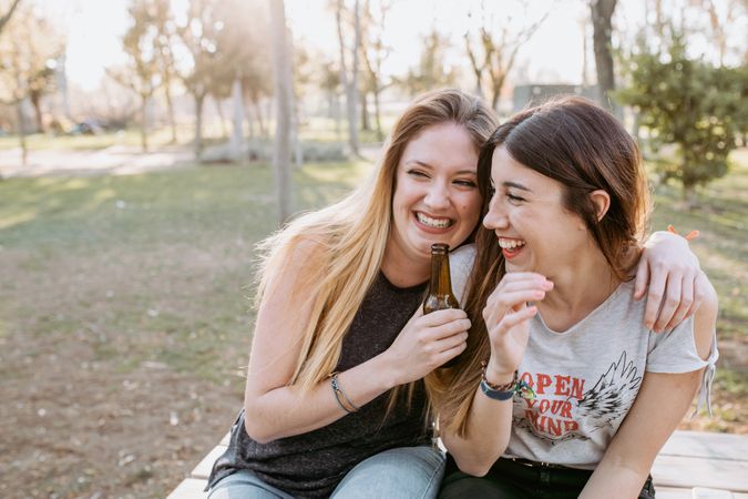 Friends hugging and laughing in park