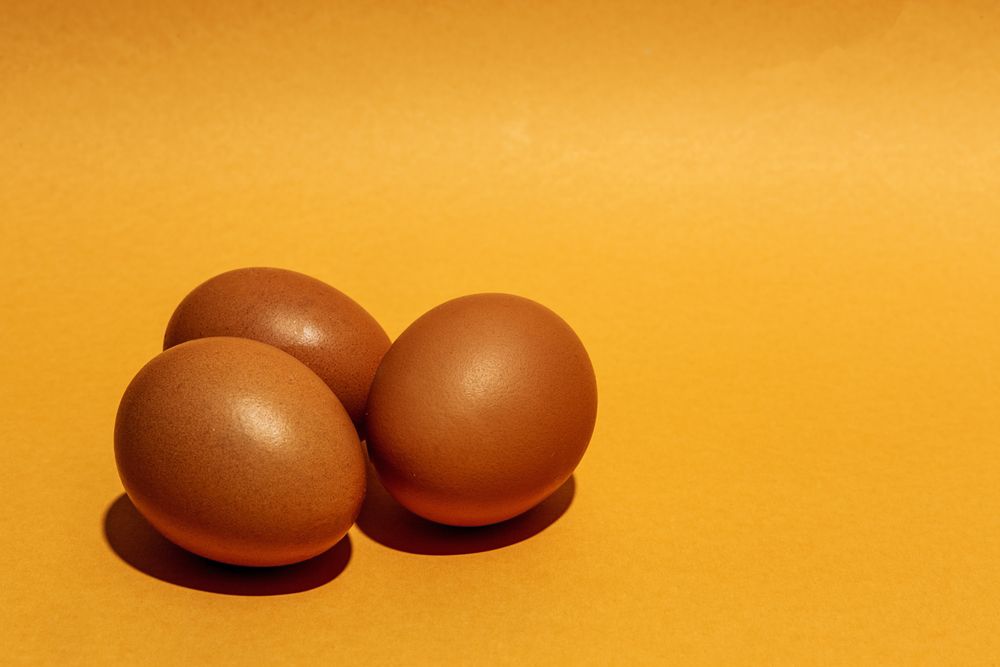 Fresh raw eggs on brown background