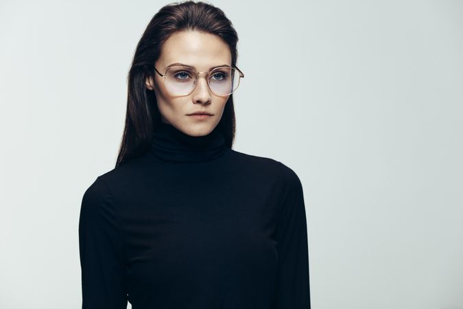Stunning young woman in dark clothes wearing glasses