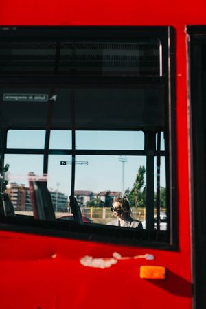 Trendy businesswoman and sunglasses leaning behind bus
