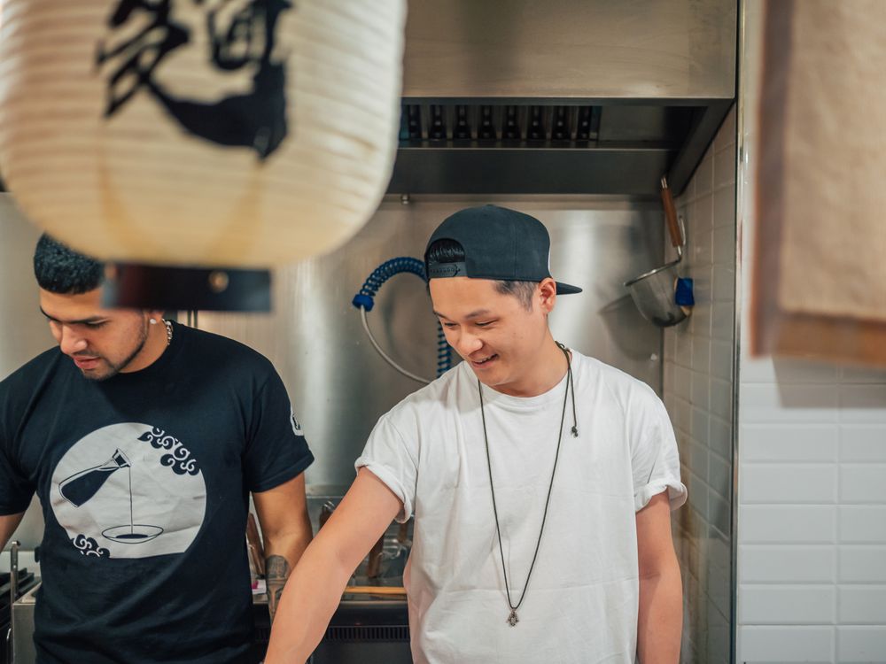 Multiethnic males cooking Asian dishes in cafe