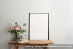 Blank picture frame mockup on table with pink flowers 43ZGj5